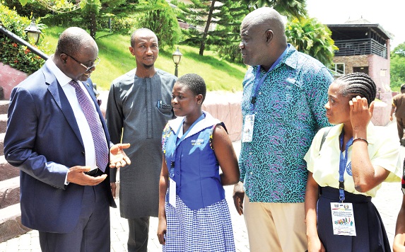 Kwaku Ampratwum Sarpong (left), Deputy Minister of Foreign Affairs and Regional Integration, explaining a point to Jessica Ewoenam Ababio, the Senior Prefect of OLA Senior High School, Ho, after the opening ceremony 
